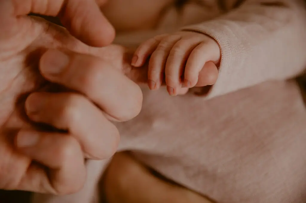 Kleine Babyhand umgreift einen Finger der Eltern