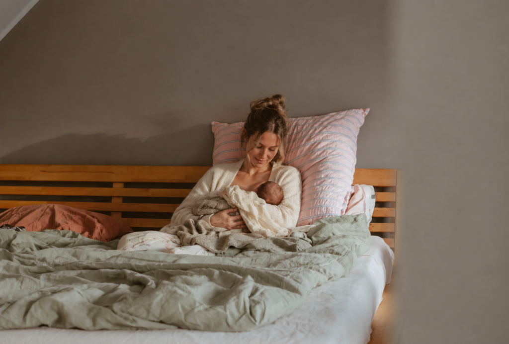 Mutter stillt ihr Baby entspannt im Bett