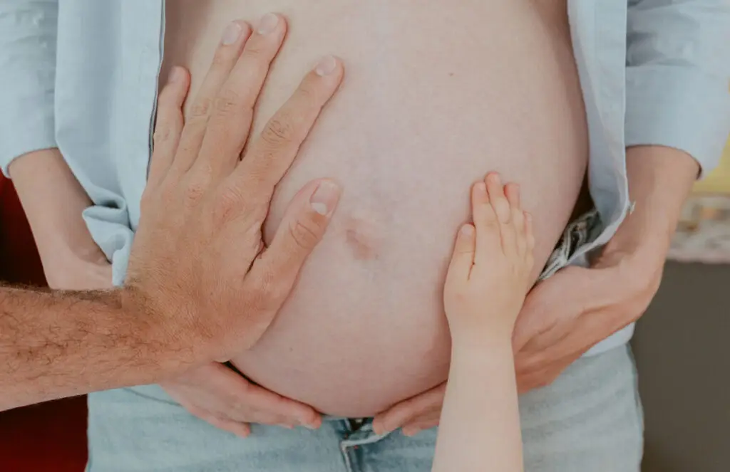 Hände der Familie auf einem Babybauch