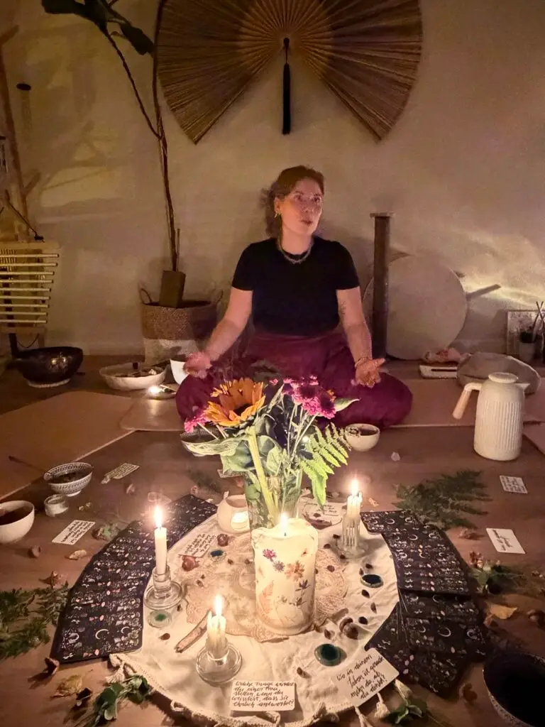 Céline leitet einen Frauenkreis mit Kerzen und Blumen