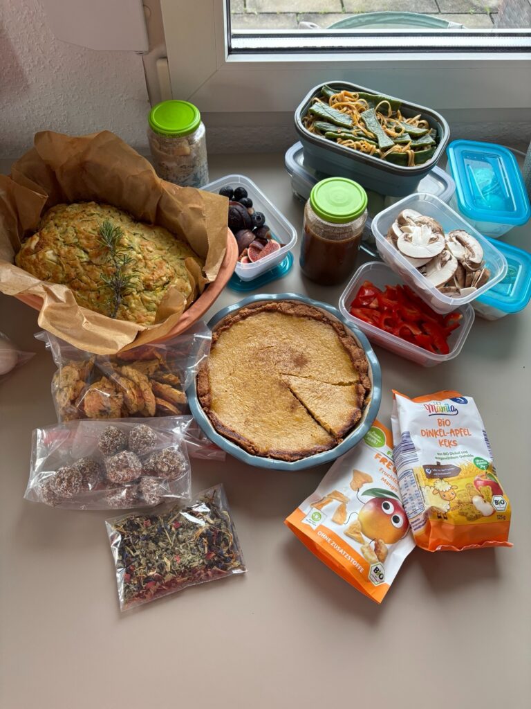 Liebevoll vorbereitetes Wochenbett-Essen: Brot, Kuchen, Obst, Energiekugeln und Tee